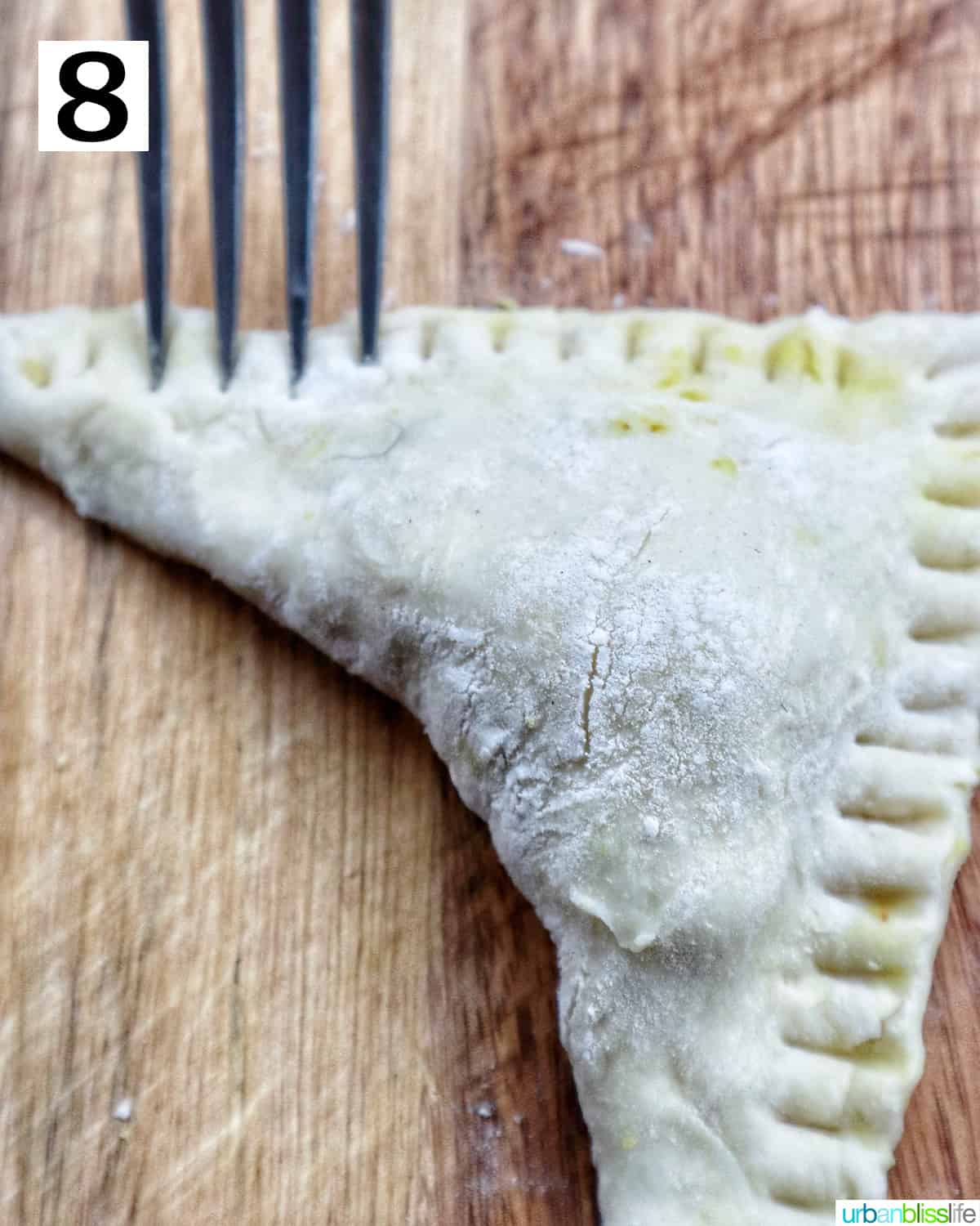 single unbaked Thai Curry puff shaped on cutting board.