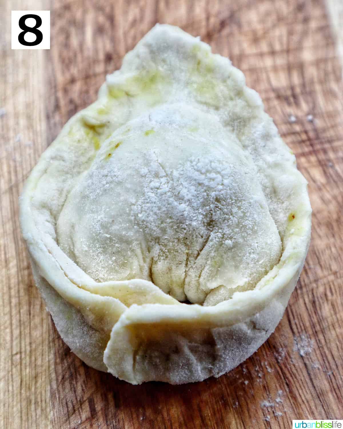 single unbaked Thai Curry puff shaped on cutting board.