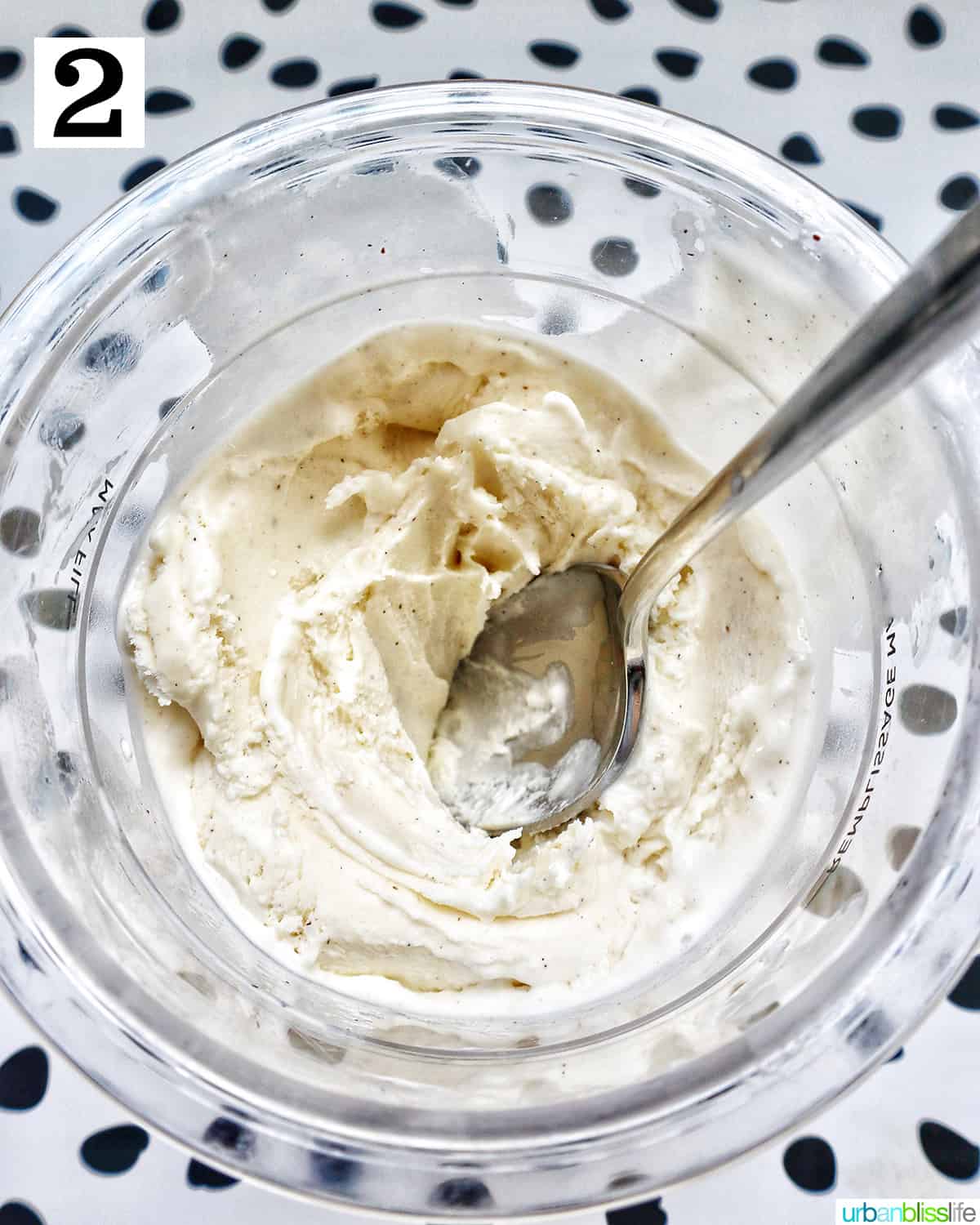 Ninja Creami container with vanilla ice cream and a spoon.