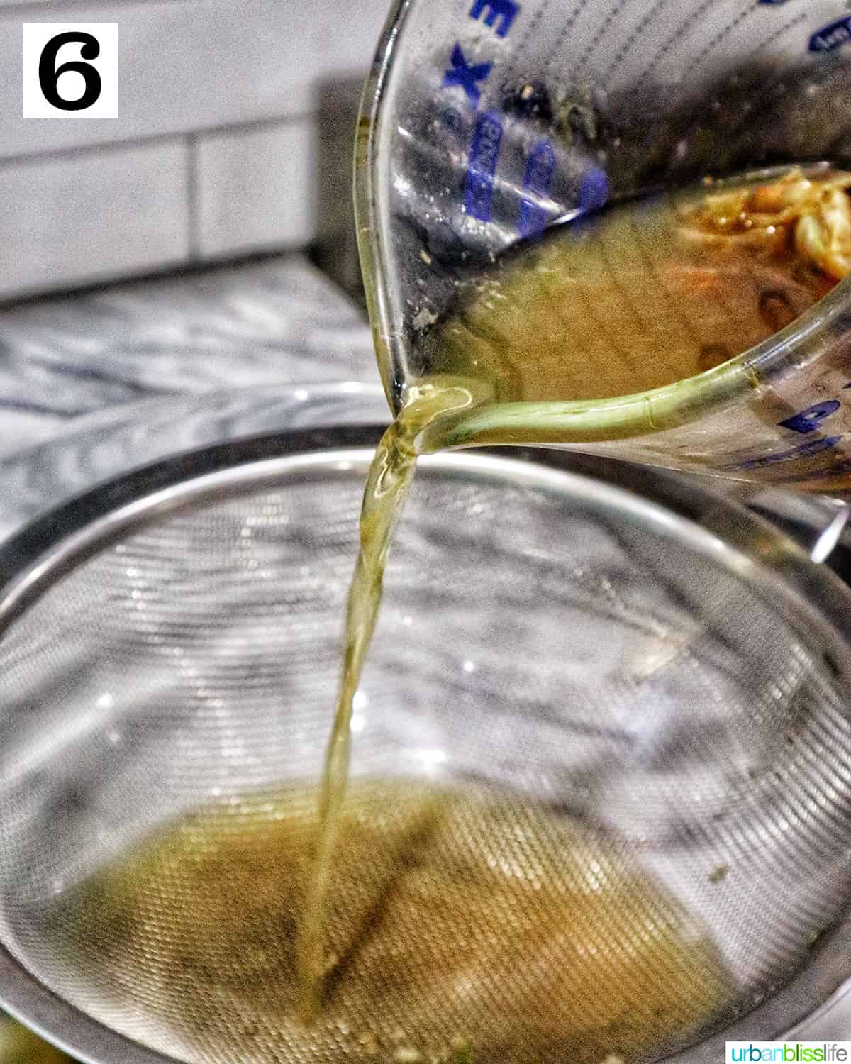 straining crab stock through a sieve.