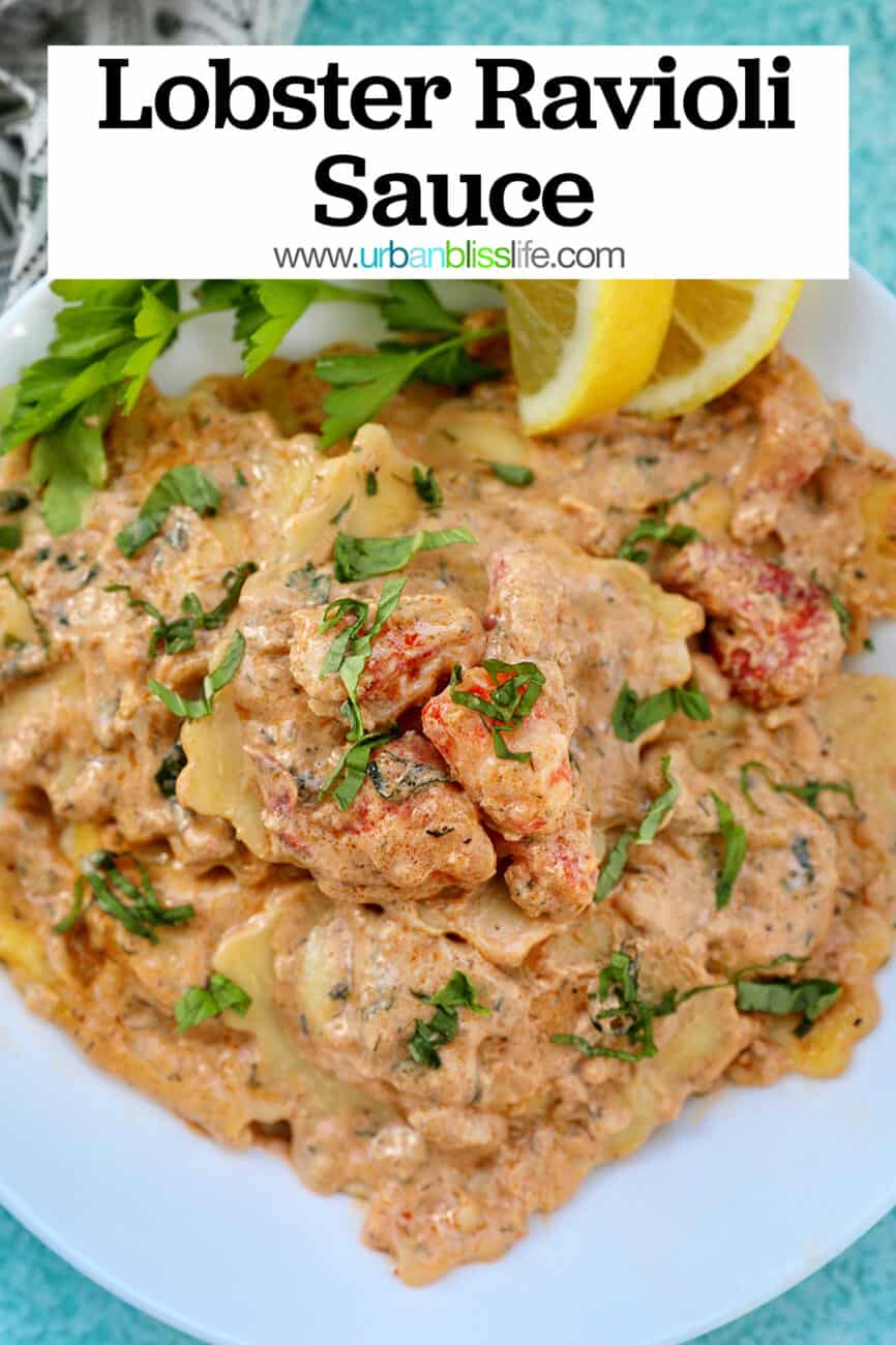 lobster ravioli sauce with lobster meat, lemon wedges, and herbs in a white bowl.