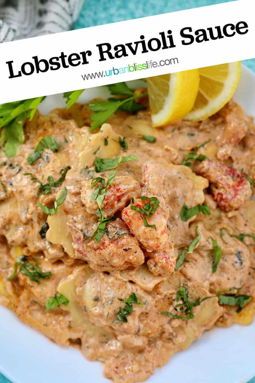 lobster ravioli sauce with lobster meat, lemon wedges, and herbs in a white bowl.