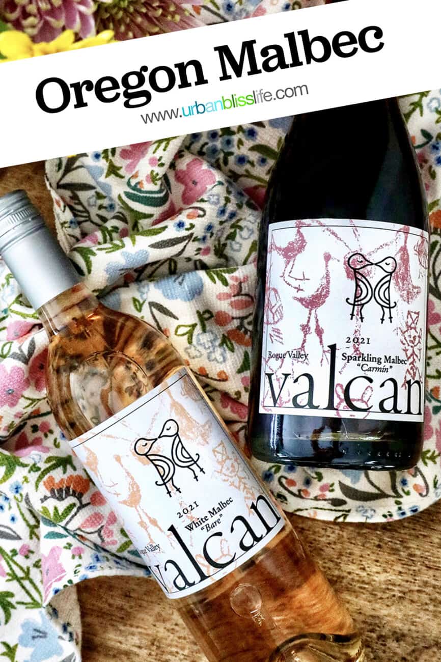 Valcan Cellars bottle of White Malbec and Sparkling Malbec on spring towel on a wine barrel with spring flowers.