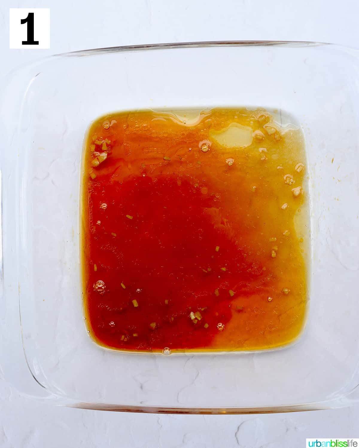 marinade in a clear glass square container.