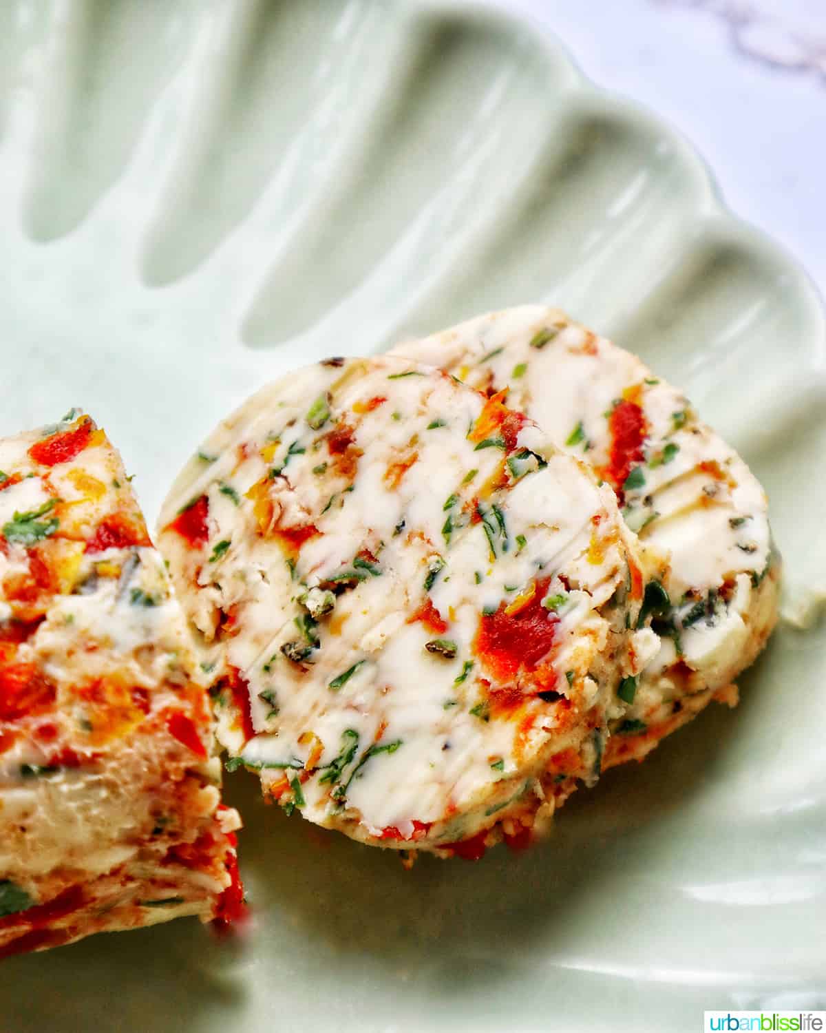slices of sun dried tomato butter on a green plate.