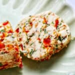 slices of sun dried tomato butter on a green plate.
