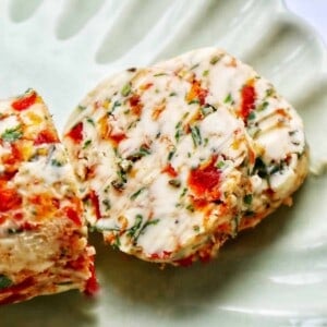 slices of sun dried tomato butter on a green plate.