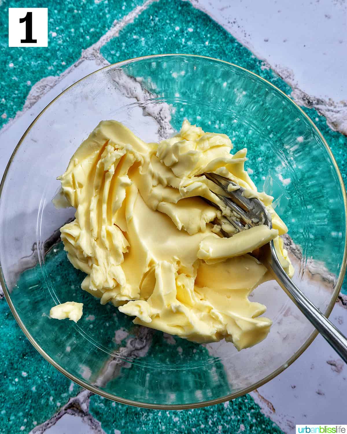 softened butter with a fork mashed in a clear bowl.