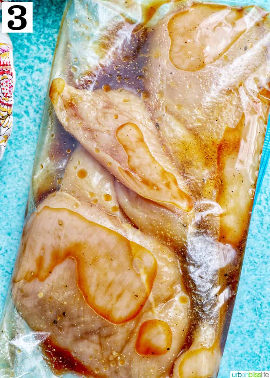 three chicken breasts in a ziplock bag with teriyaki marinade.