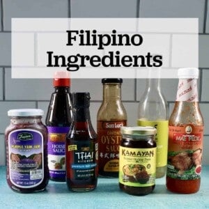 several jars and bottles of Filipino ingredients used in Filipino cuisine on a blue table with text that reads Filipino Ingredients.