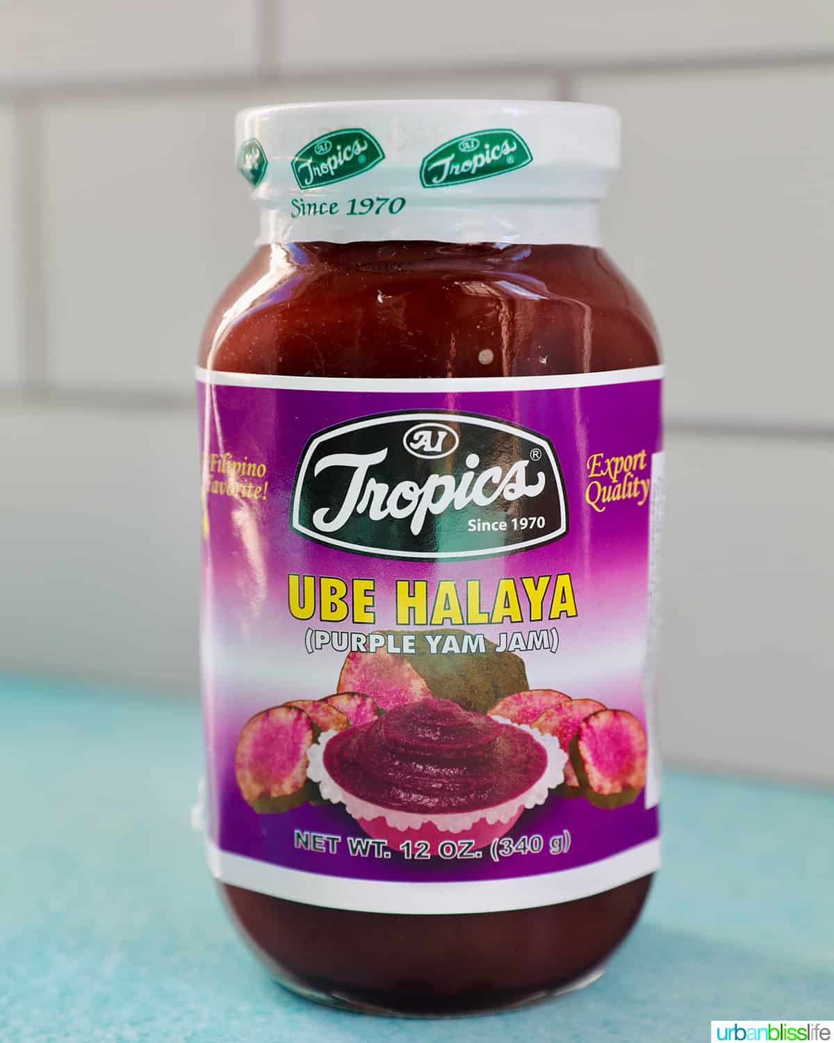 jar of ube halaya (ube jam) on a blue table with white tile background.