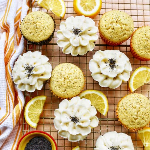 Lemon poppyseed cupcakes undecorated next to cupcakes with buttercream frosting flower decorations next to lemon slices.