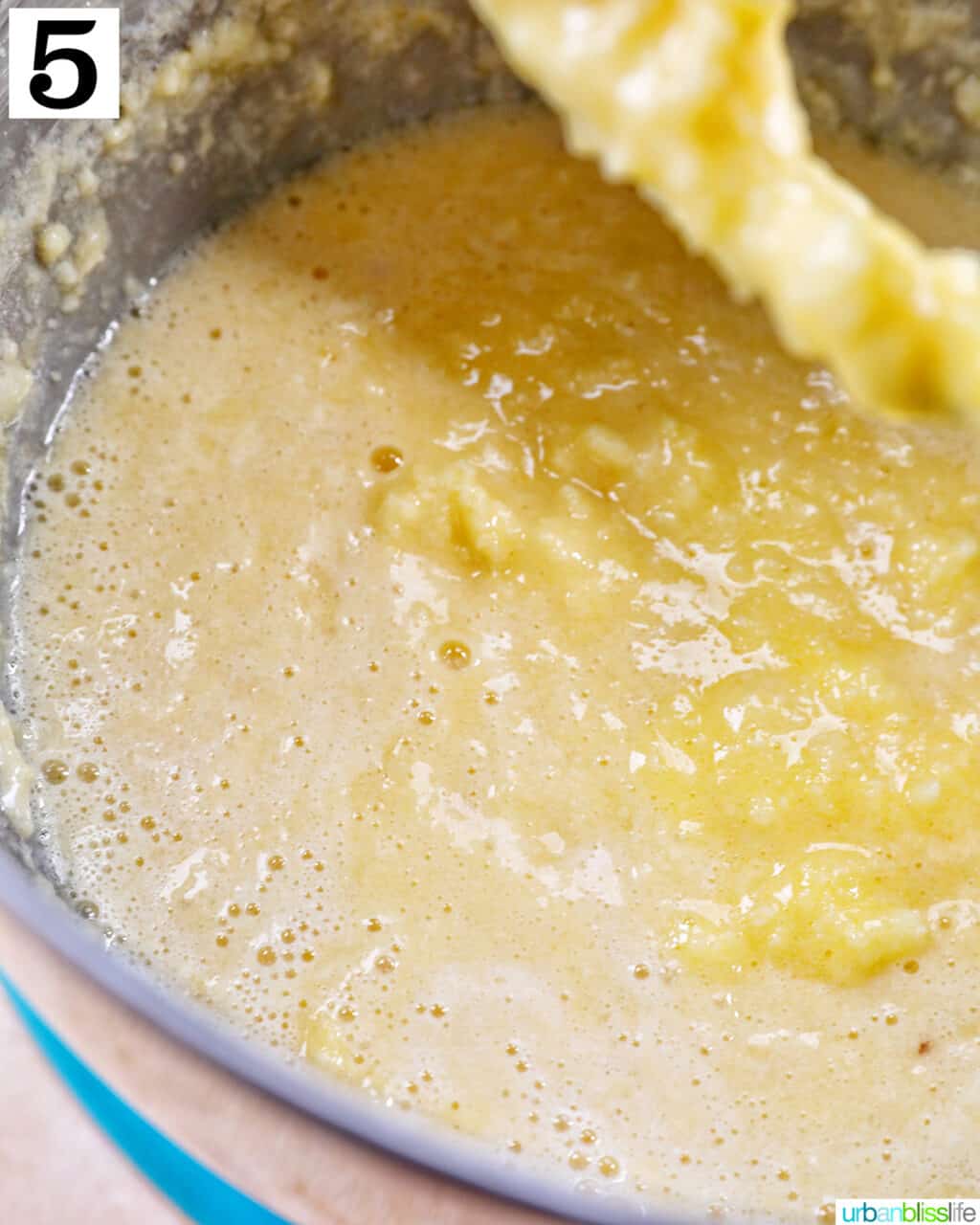 wet ingredients for cupcake batter mixing in a stand mixer with paddle attachment.