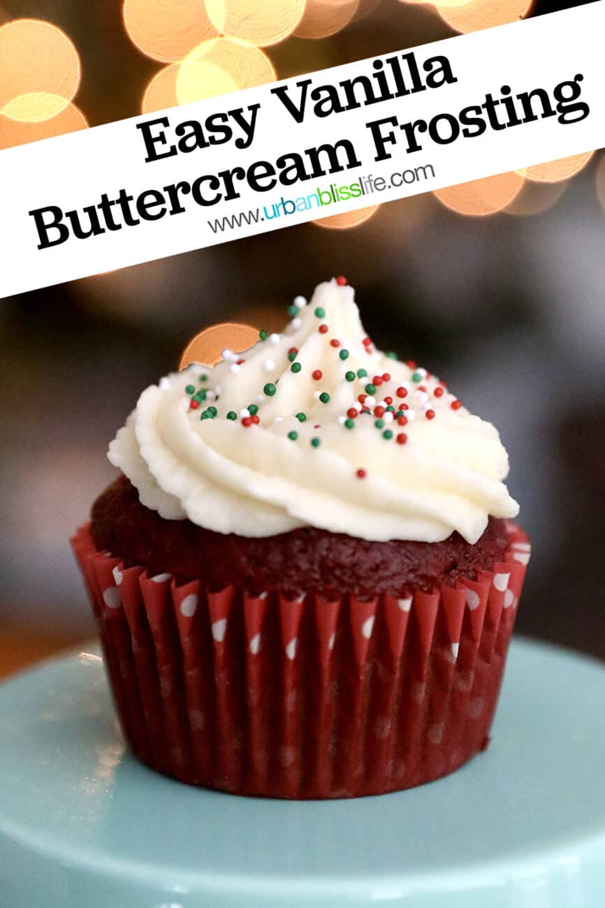 vanilla buttercream frosting on a red velvet cupcake with bokeh twinkle lights in the background.