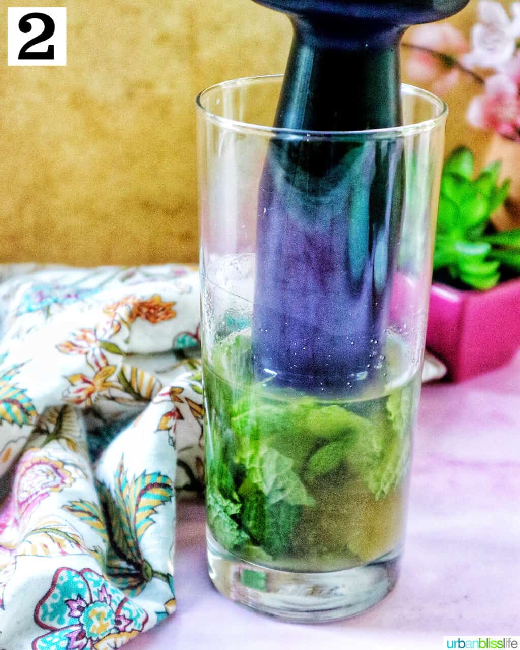 muddling mint leaves to make a mango mojito cocktail.