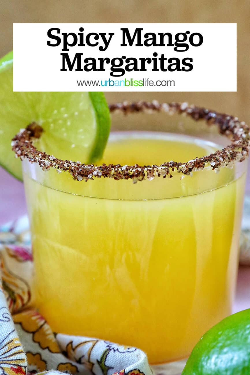 glass of spicy mango margarita with lime slice garnish and chili powder salt rim.