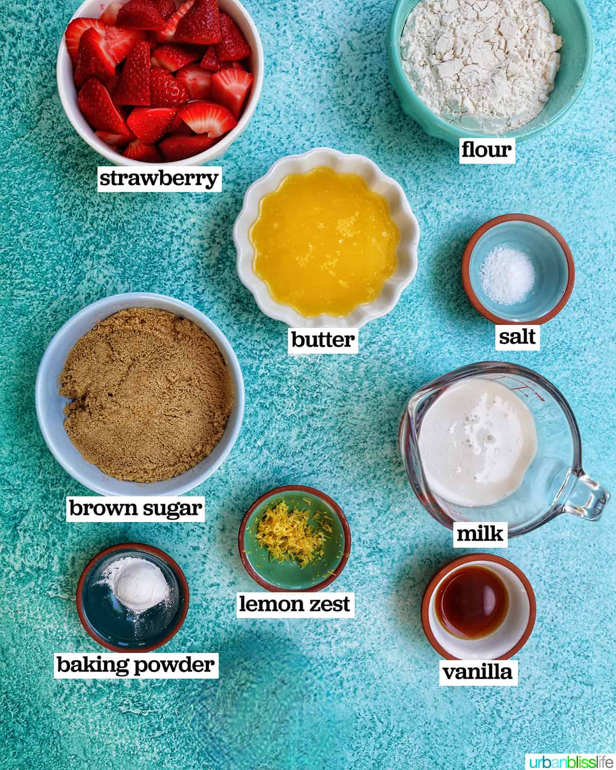 bowls of ingredients to make Strawberry Spoon Cake on a blue table.