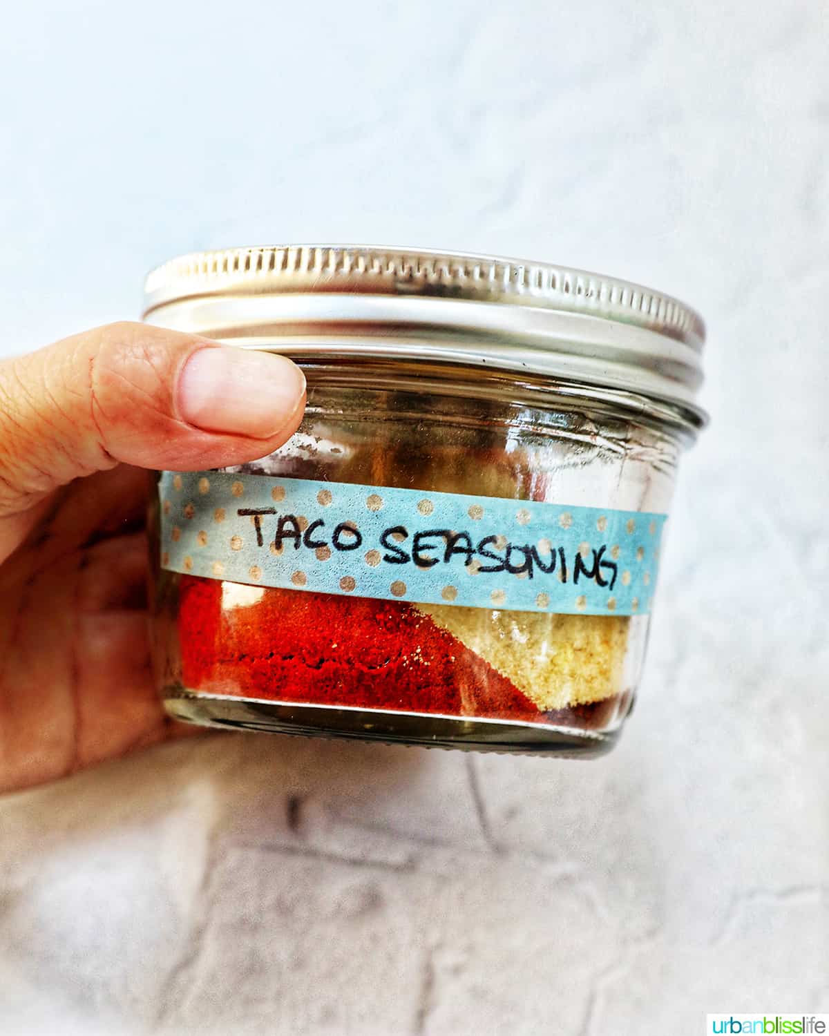 hand holding a jar of easy homemade taco seasoning