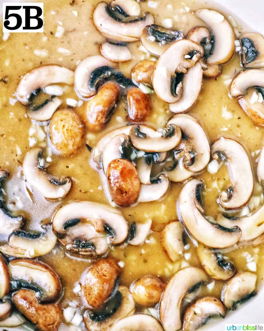 over chopped mushrooms cooking in a pan.