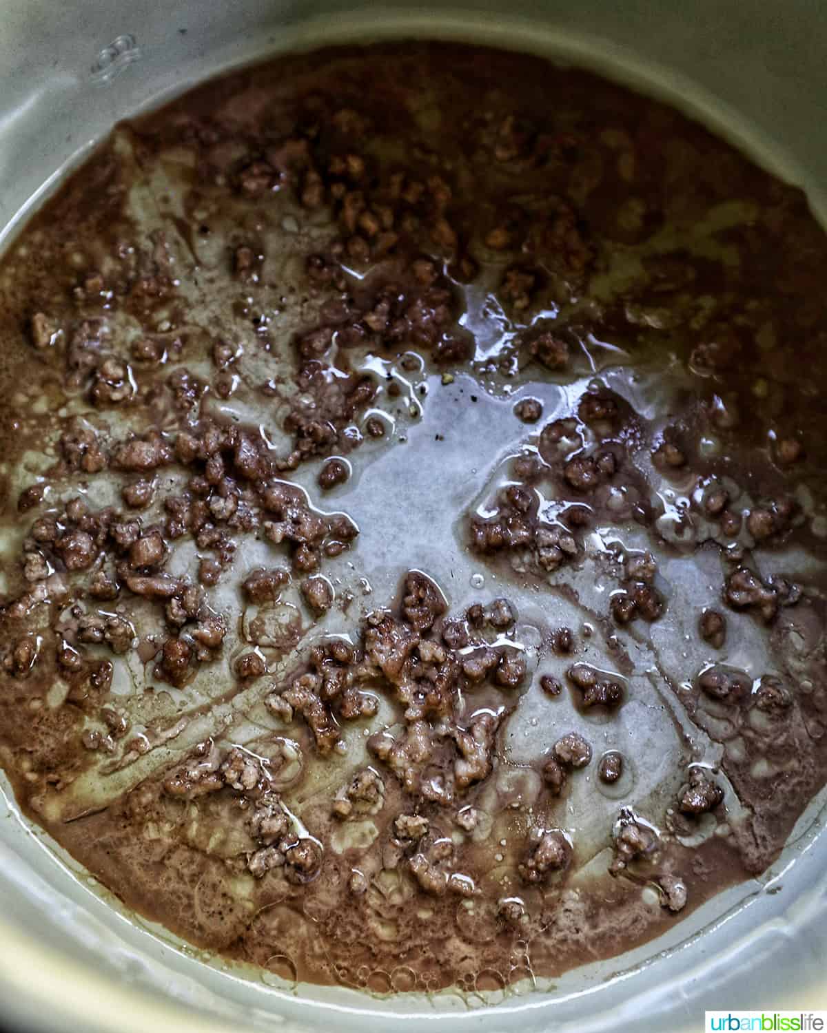 ground beef drained at the bottom of an air fryer.