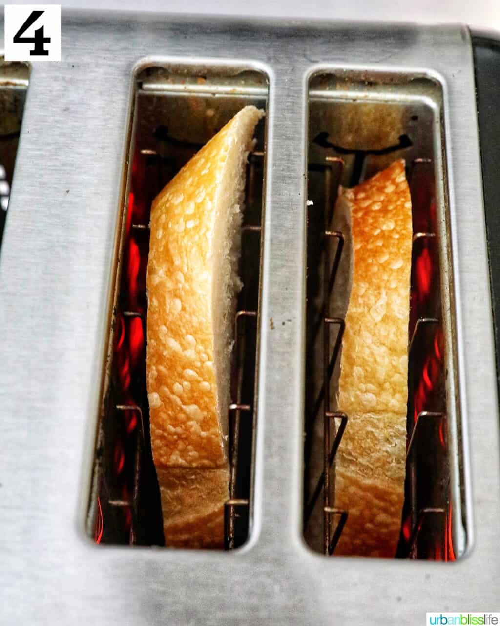 two pieces of french bread slices in a toaster oven.