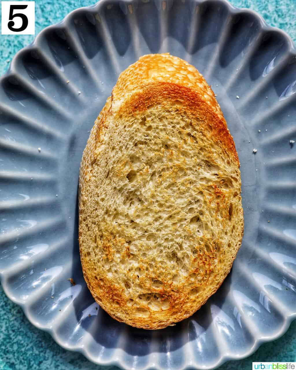 a piece of toast on a blue plate.