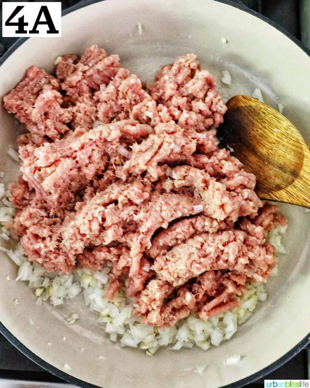 ground turkey added to onions and garlic in a large white skillet.