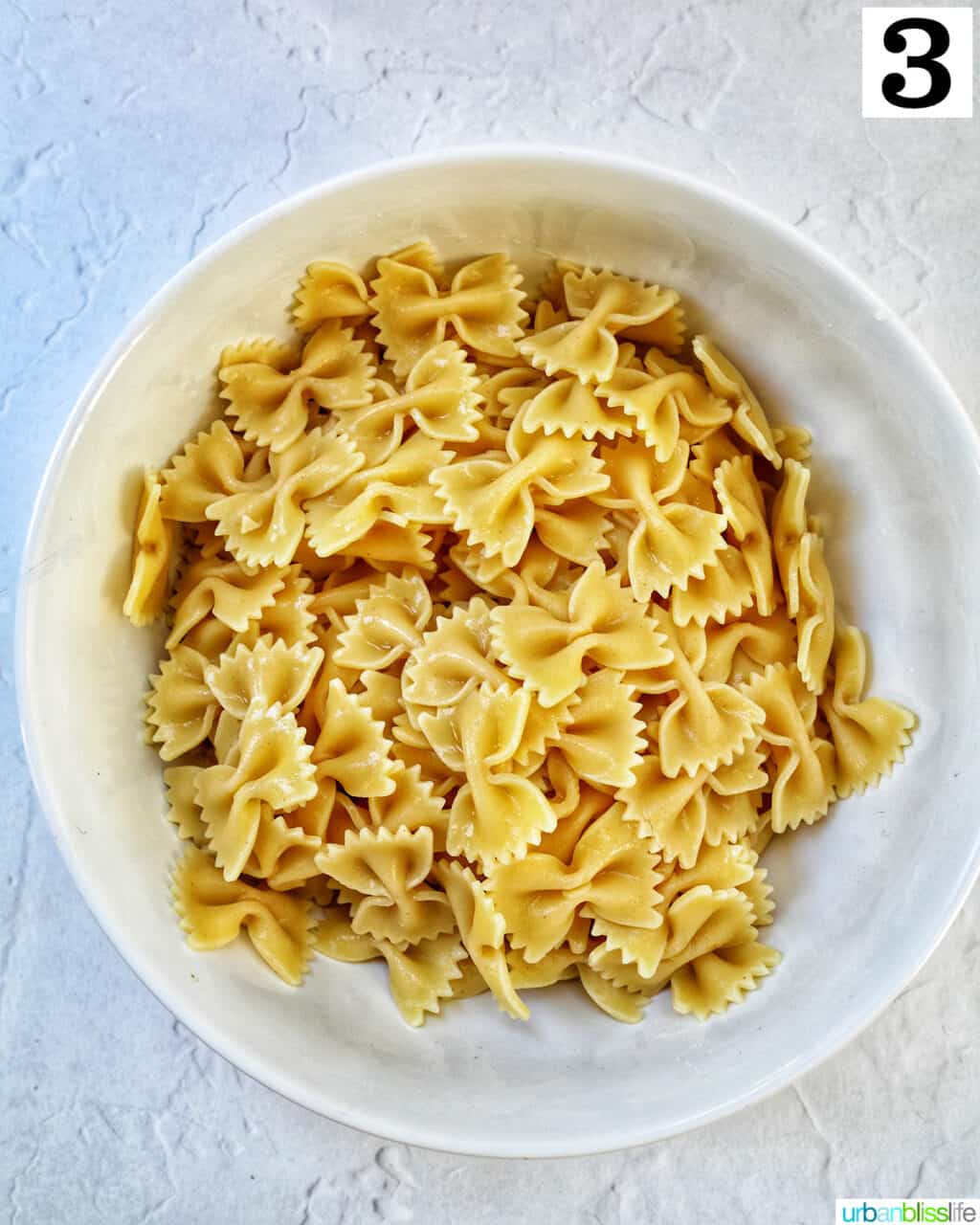white bowl full of bowtie farfalle pasta.