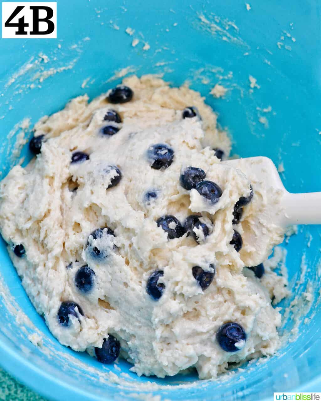 folding blueberries into dough to make lemon blueberry cookies.