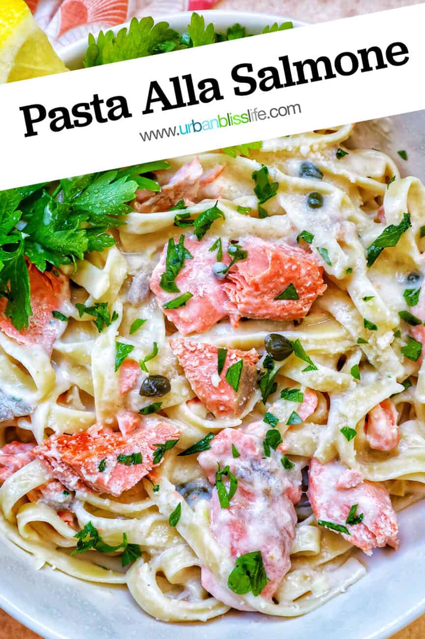 pasta alla salmone with garnishes of parsley and lemon slices in a white bowl with title text that reads "pasta alla salmone."