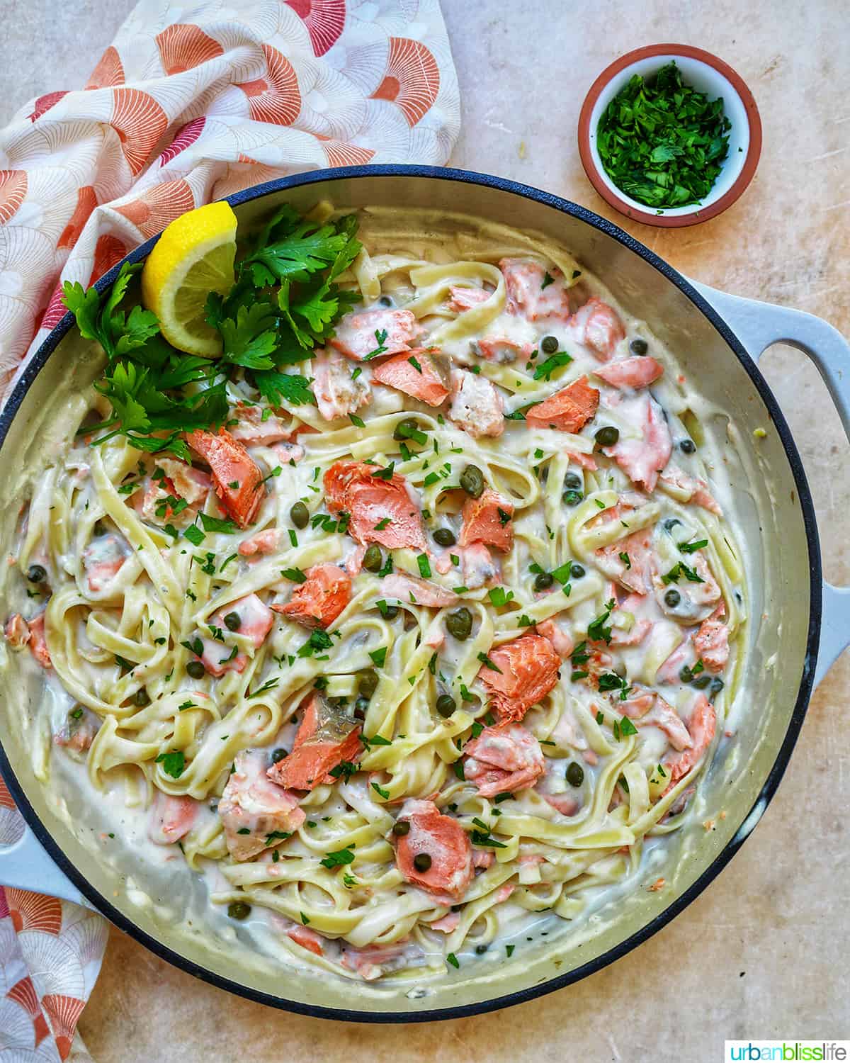 pasta alla salmone with garnishes of parsley and lemon slices in a large saucepan.