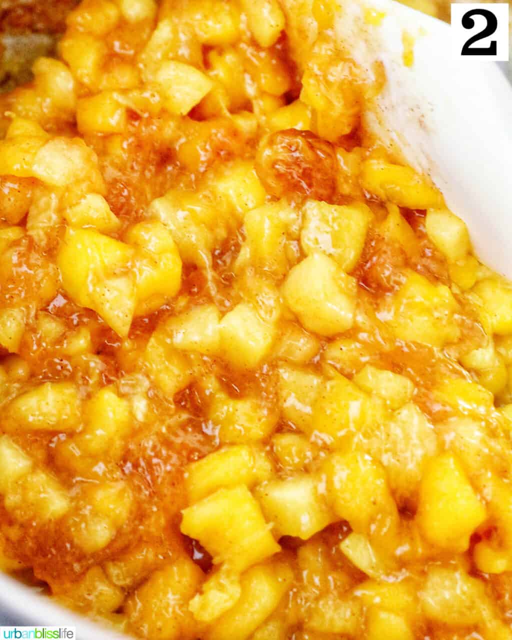 diced mangoes and peaches cooking in a saucepan.