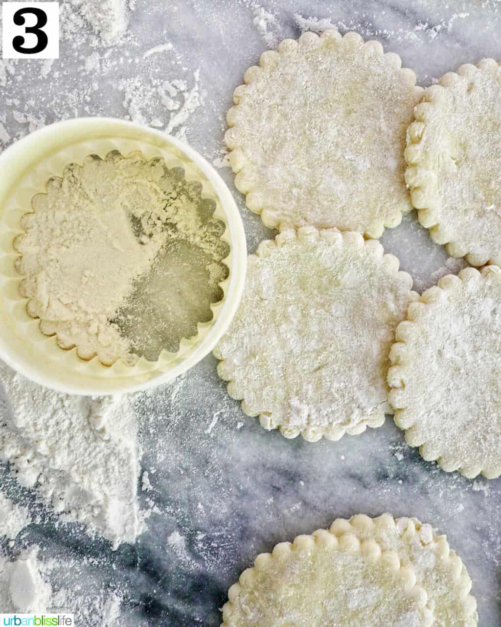 round cookie cutter with cut out puff pastry dough.