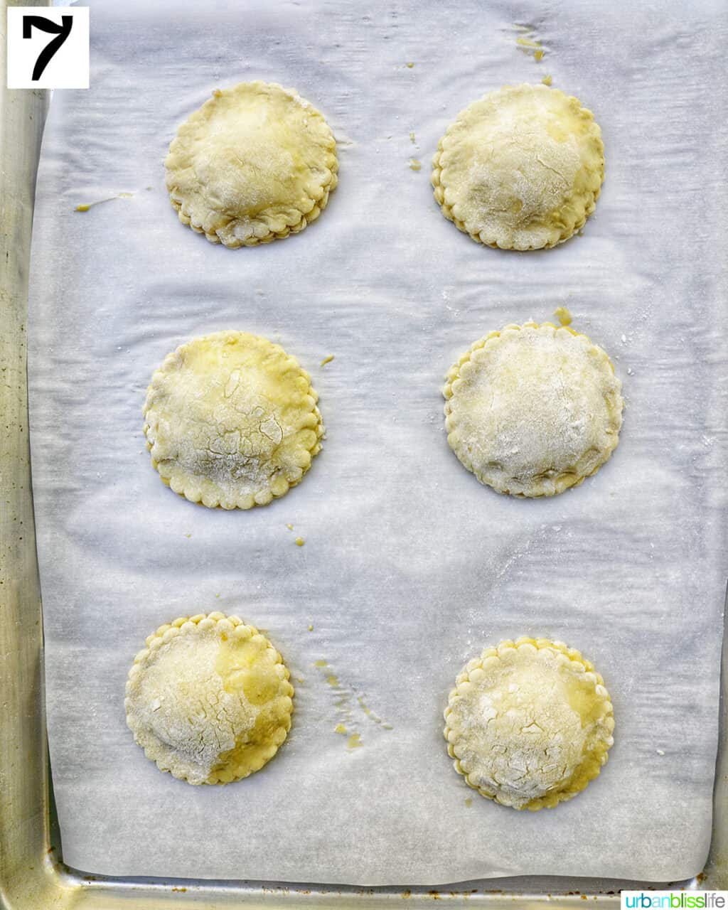 round mini peach mango hand pies ready to bake in the oven.