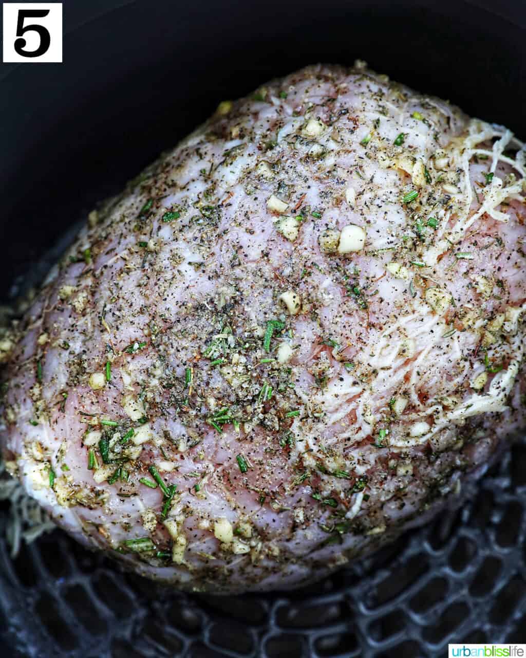 seasoned turkey breast in an air fryer basket.