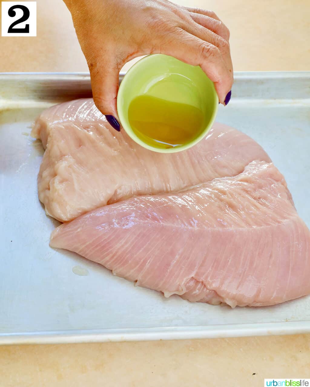 pouring olive oil onto turkey tenderloins.