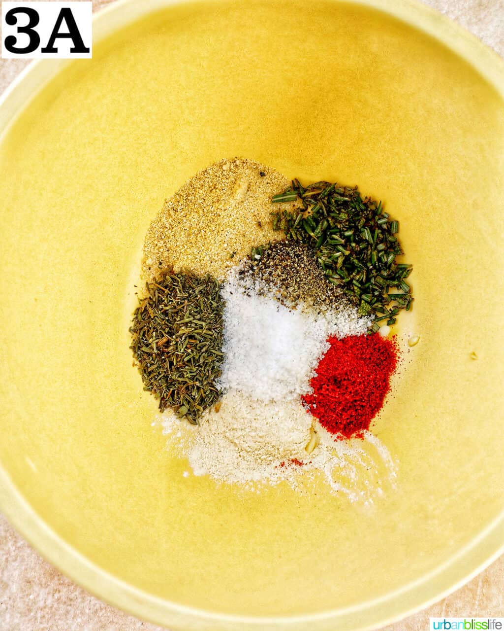yellow bowl full of different spices and seasonings.