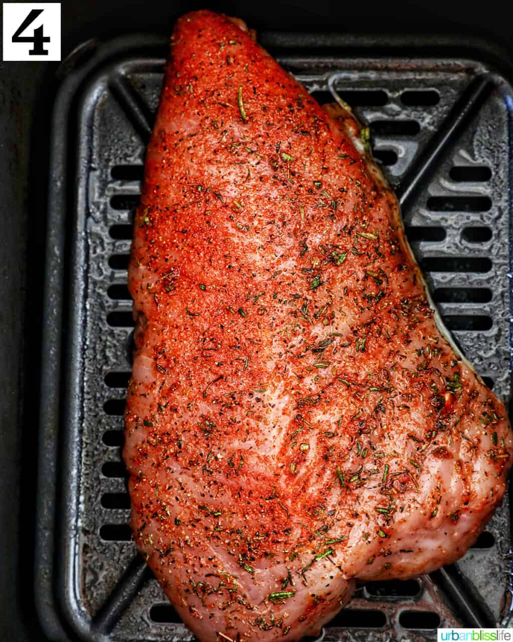 seasoned turkey tenderloin in an air fryer basket.
