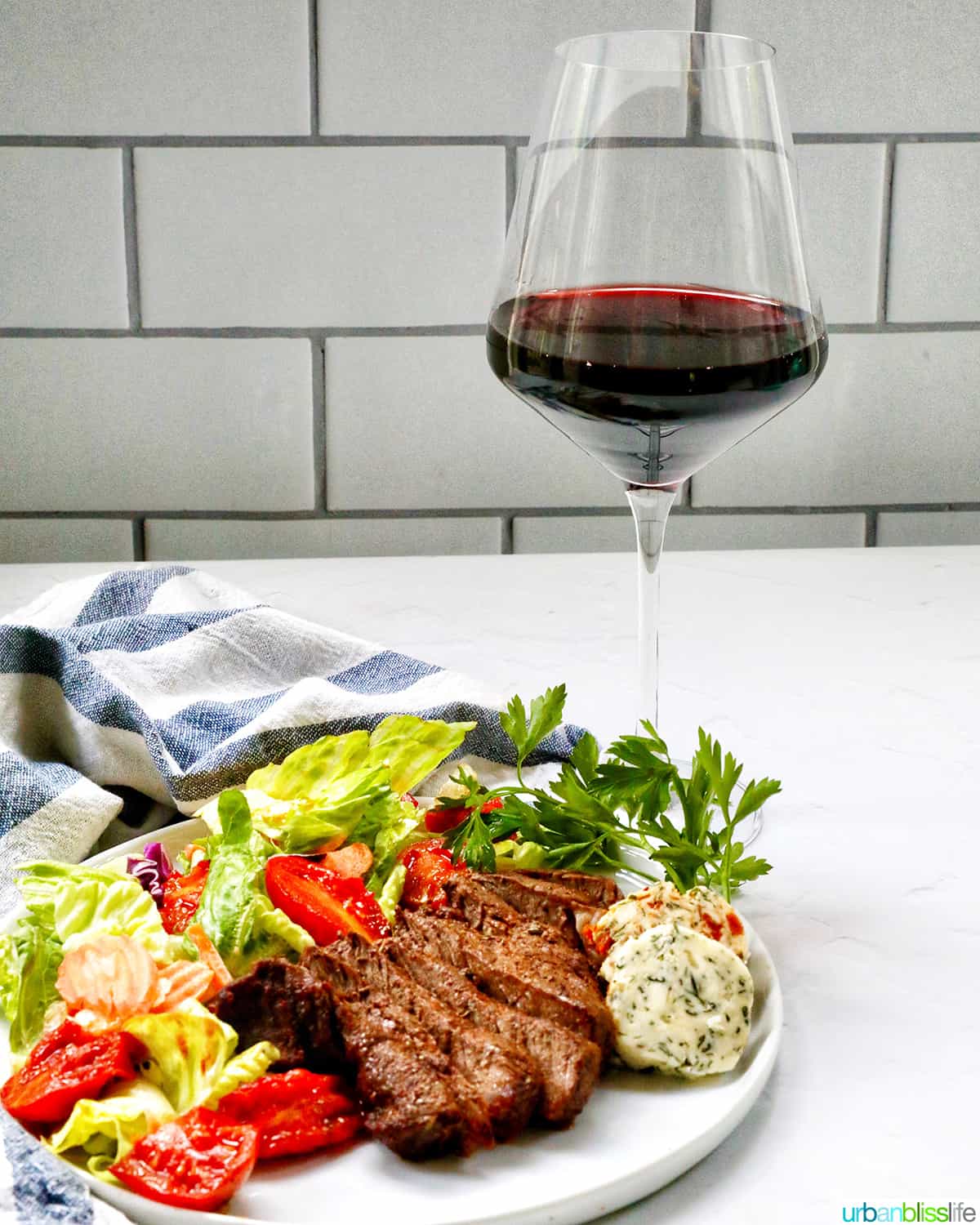glass of red wine with steak and salad.