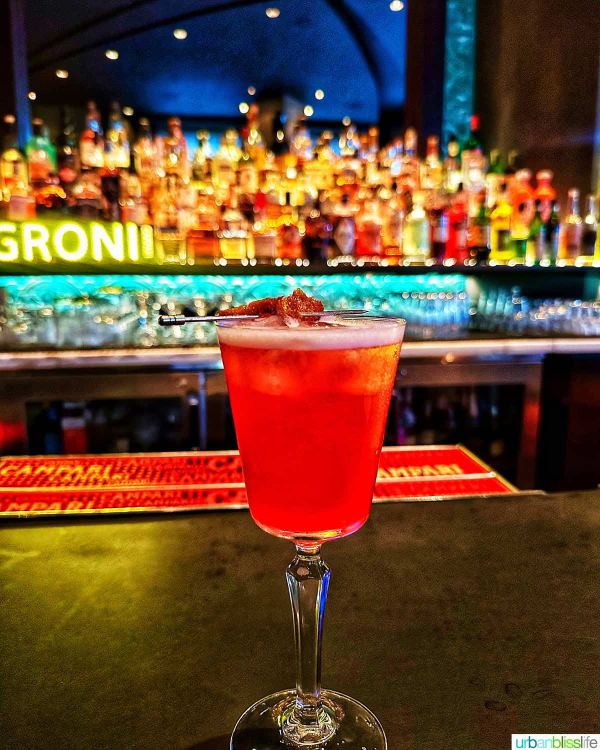 cocktail at the bar with colorful bottles in the background at the Raven Room in Whistler BC Canada.