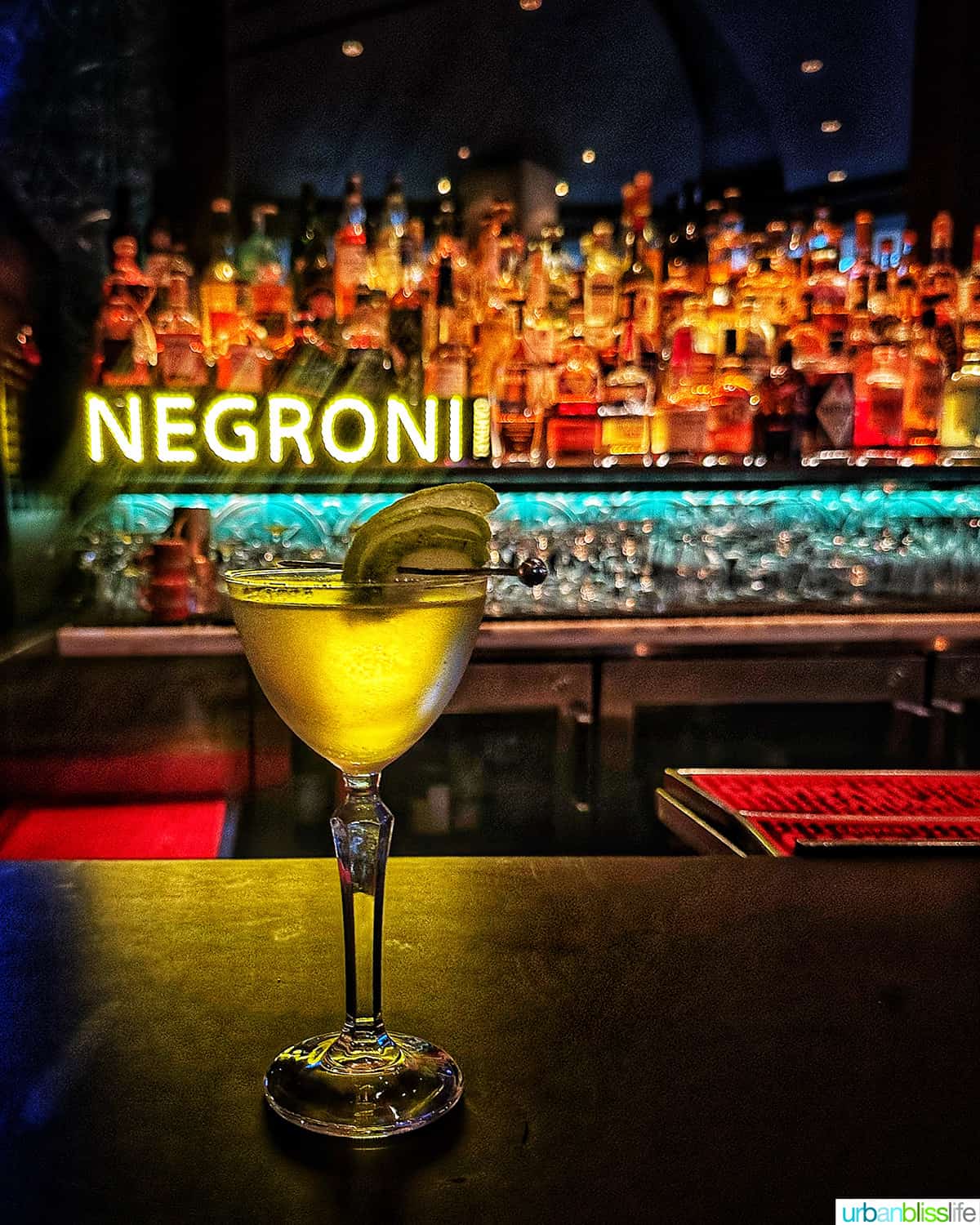 cocktail at the bar with colorful bottles in the background at the Raven Room in Whistler BC Canada.