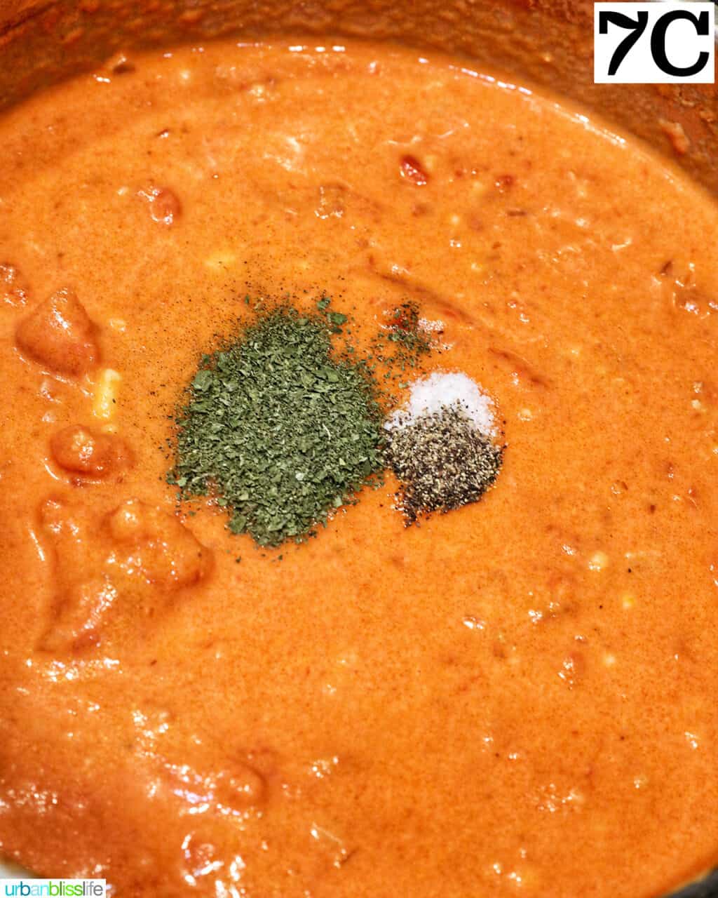 herbs added to tomato sauce in a saucepan.
