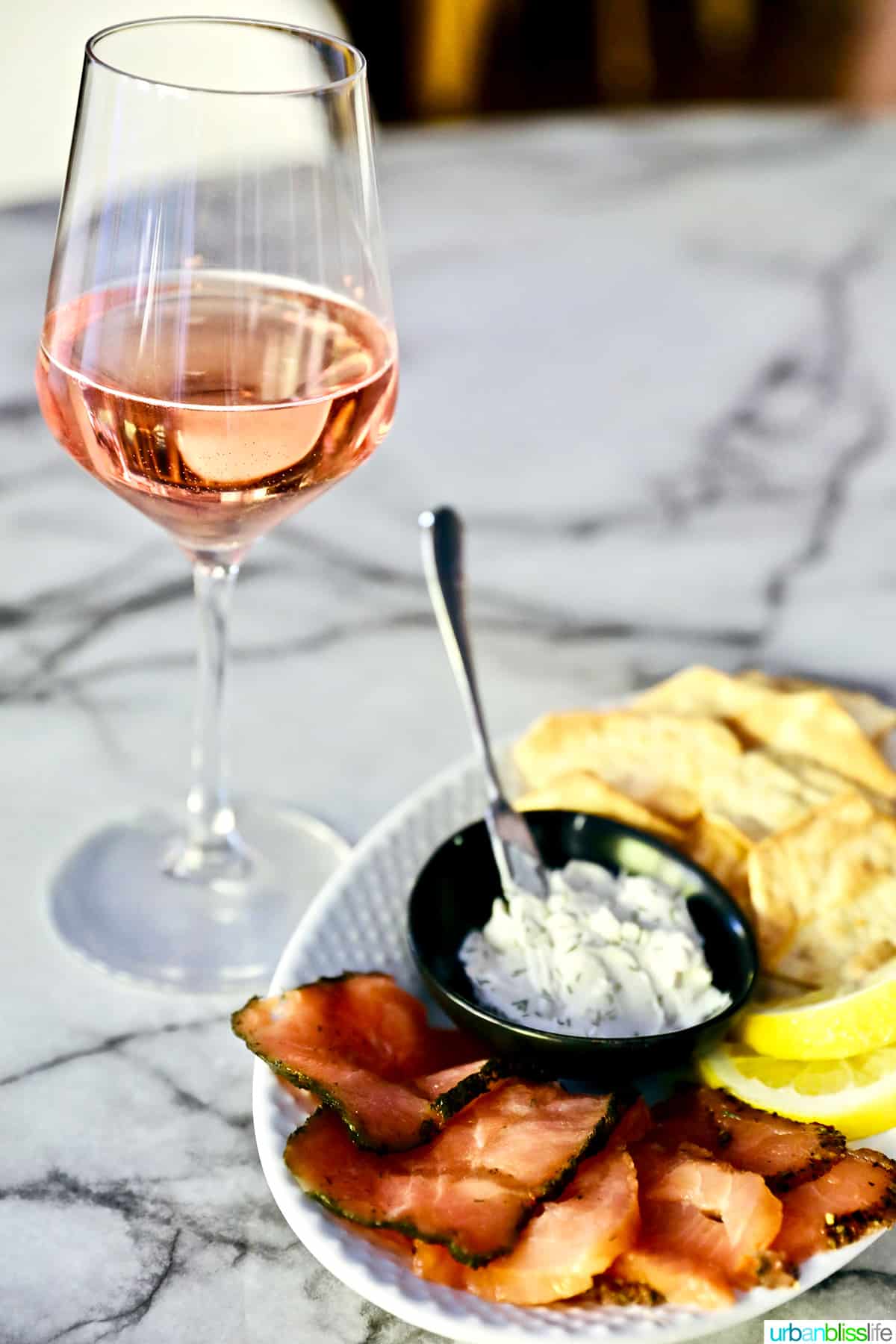 plate of smoked salmon and dip with glass of rosรฉ wine.