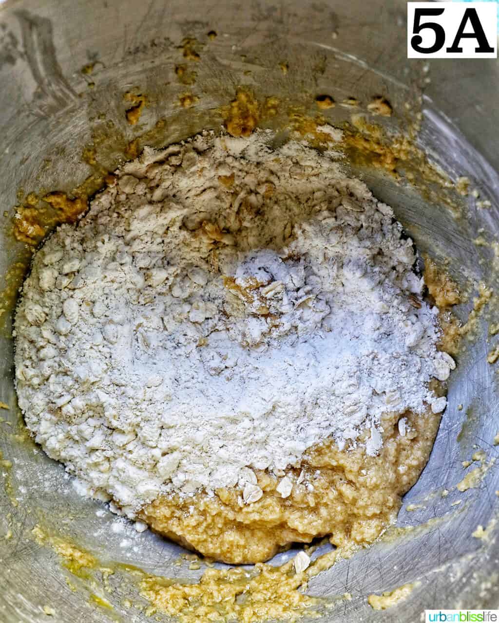 adding dry ingredients to wet ingredients in a stand mixer bowl.