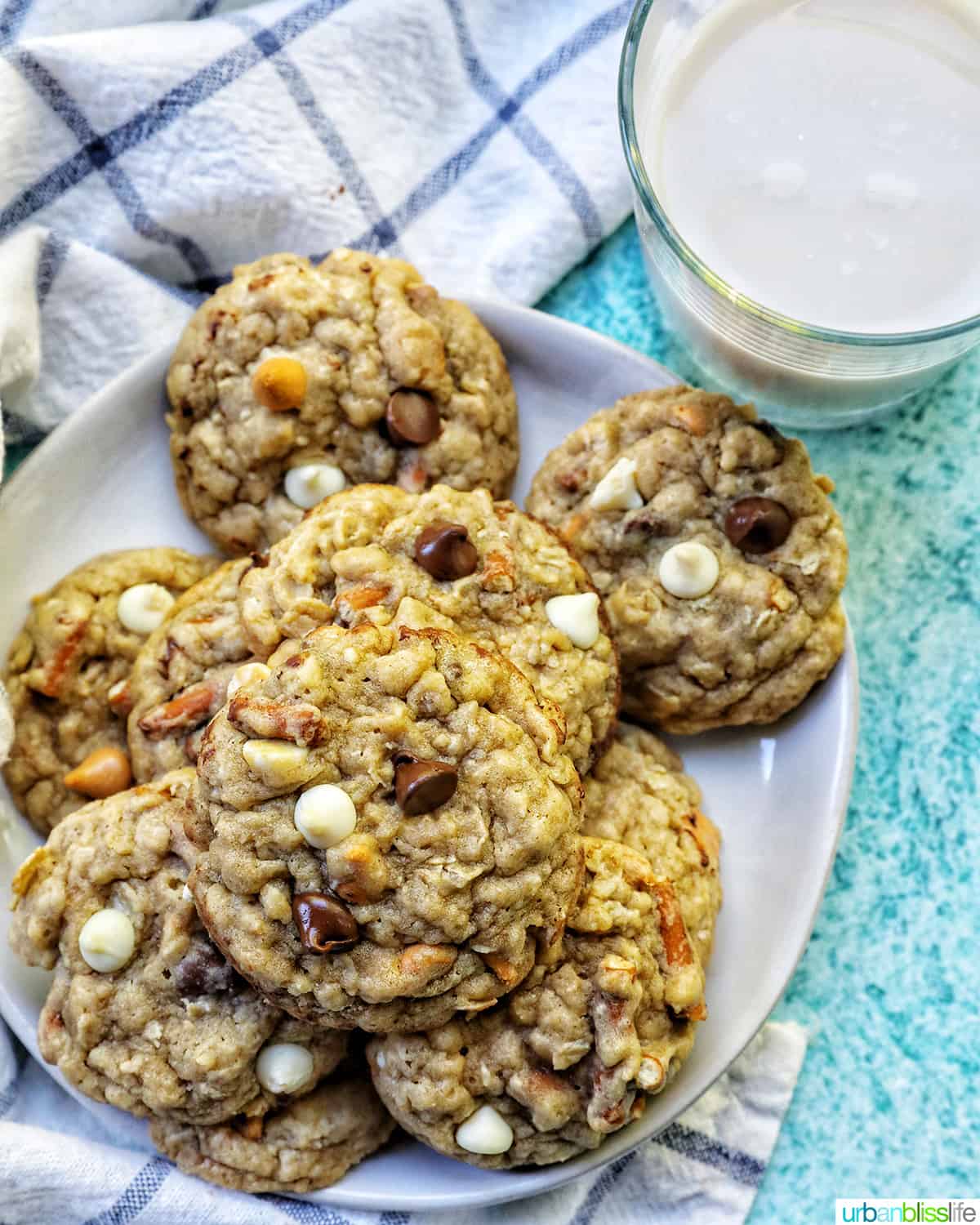 chocolate chip pretzel cookies stacked on a plate with a glass of milk.