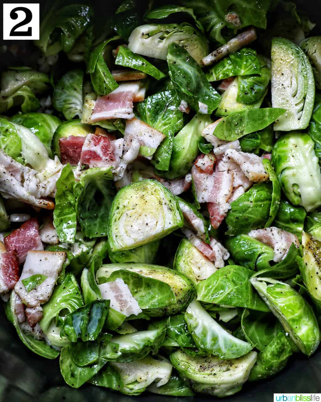 bowl of brussels sprouts with bacon in an air fryer basket.