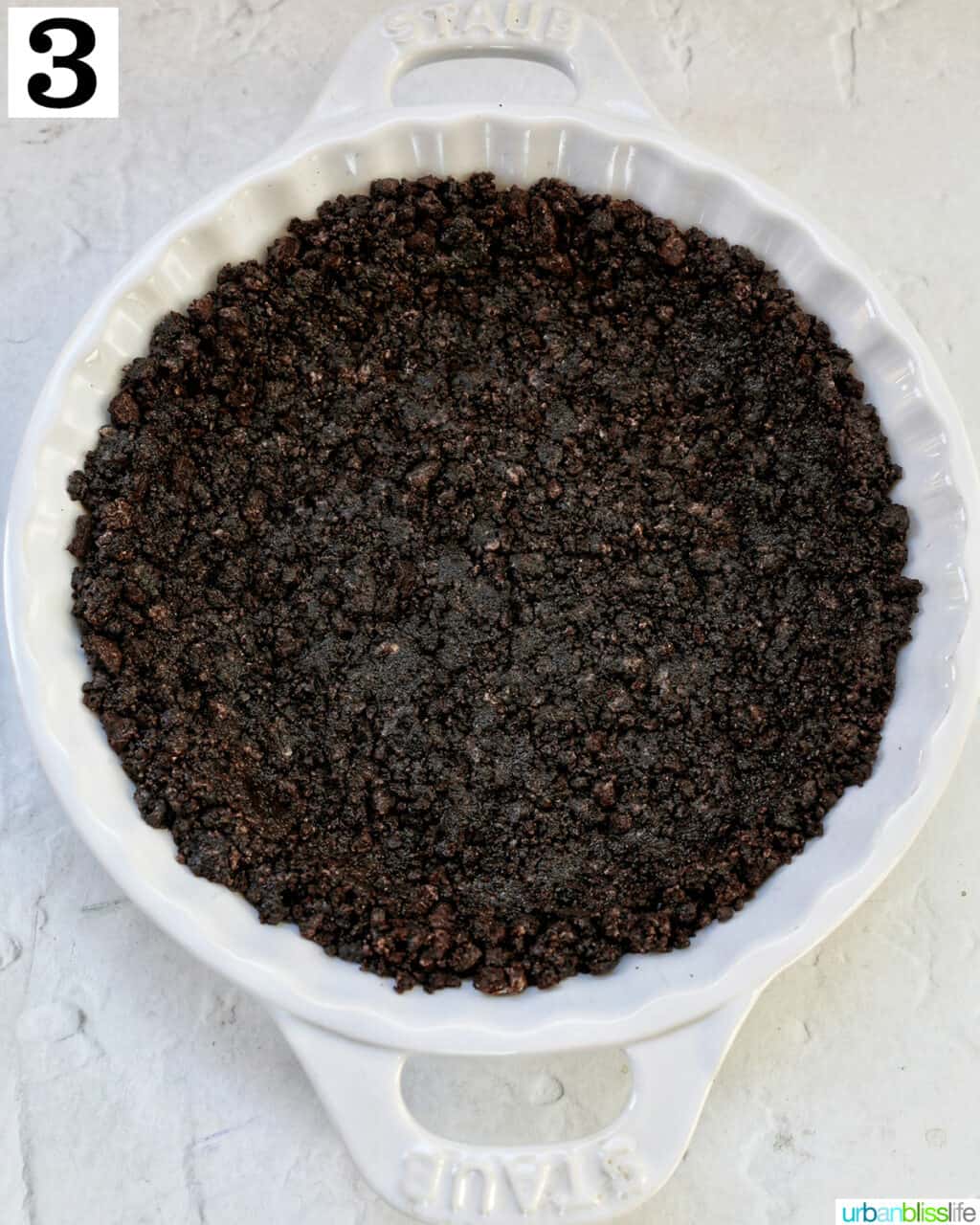 crushed oreo crust set in a white pie plate.