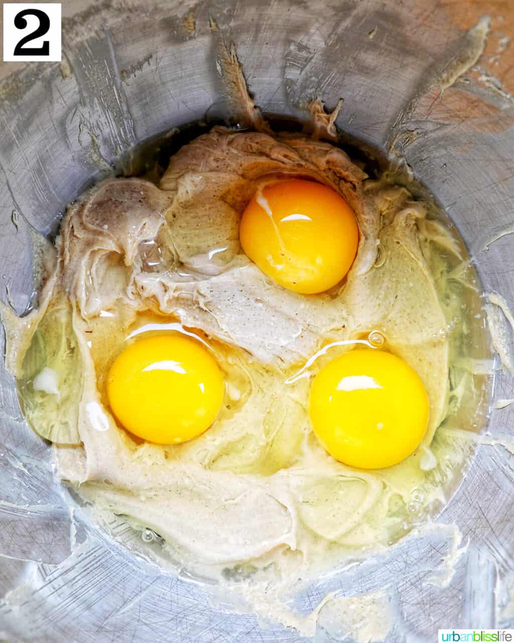 eggs added to cinnamon pie batter in a stainless steel bowl.