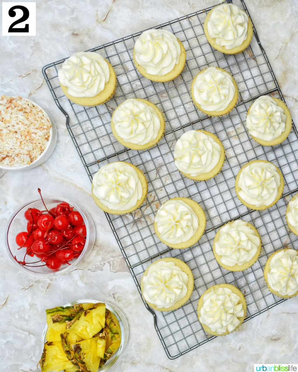 pina colada cupcakes frosted on a wire rack.
