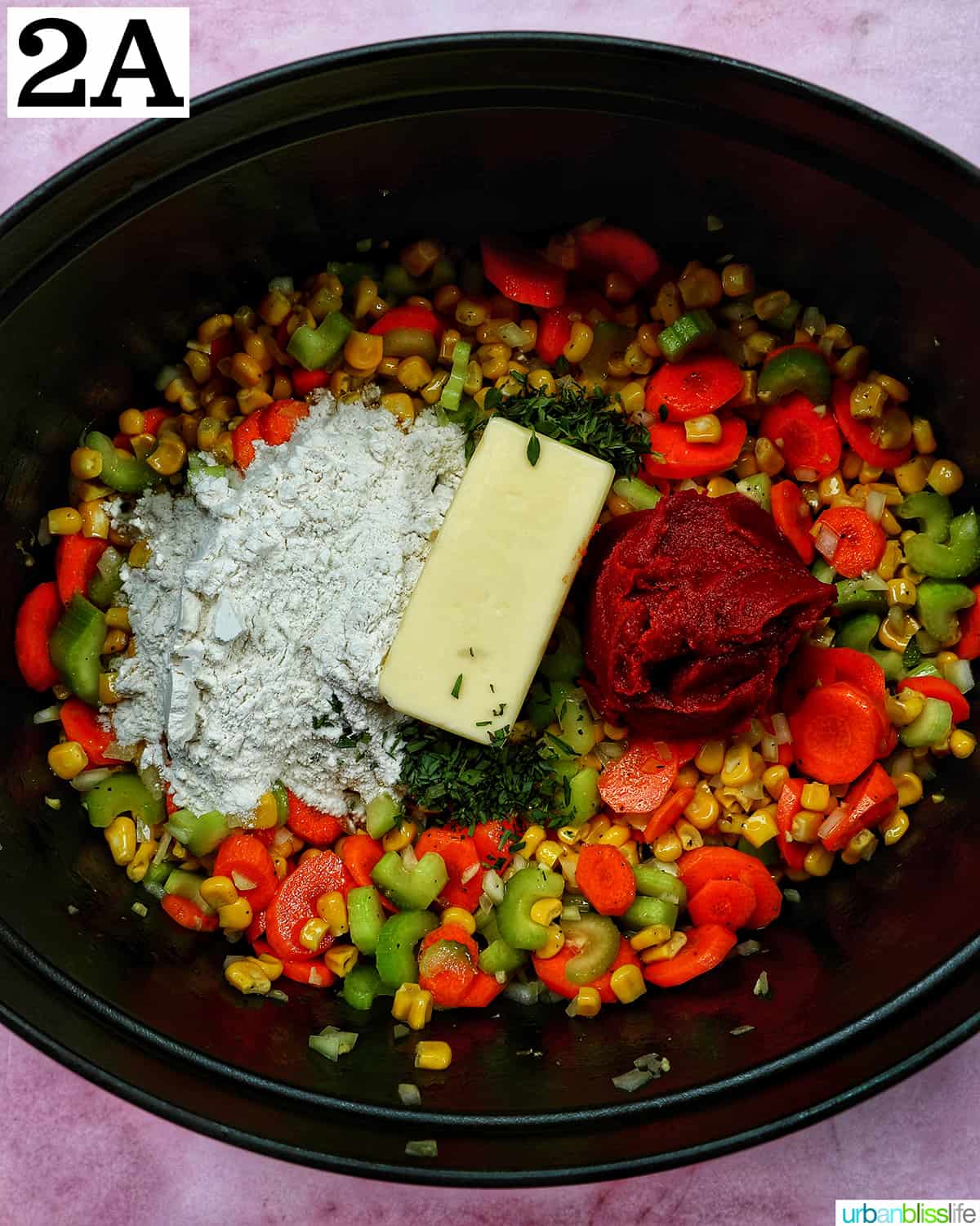 butter and spices added to celery, carrots, corn, onions, and spices in a Dutch oven.